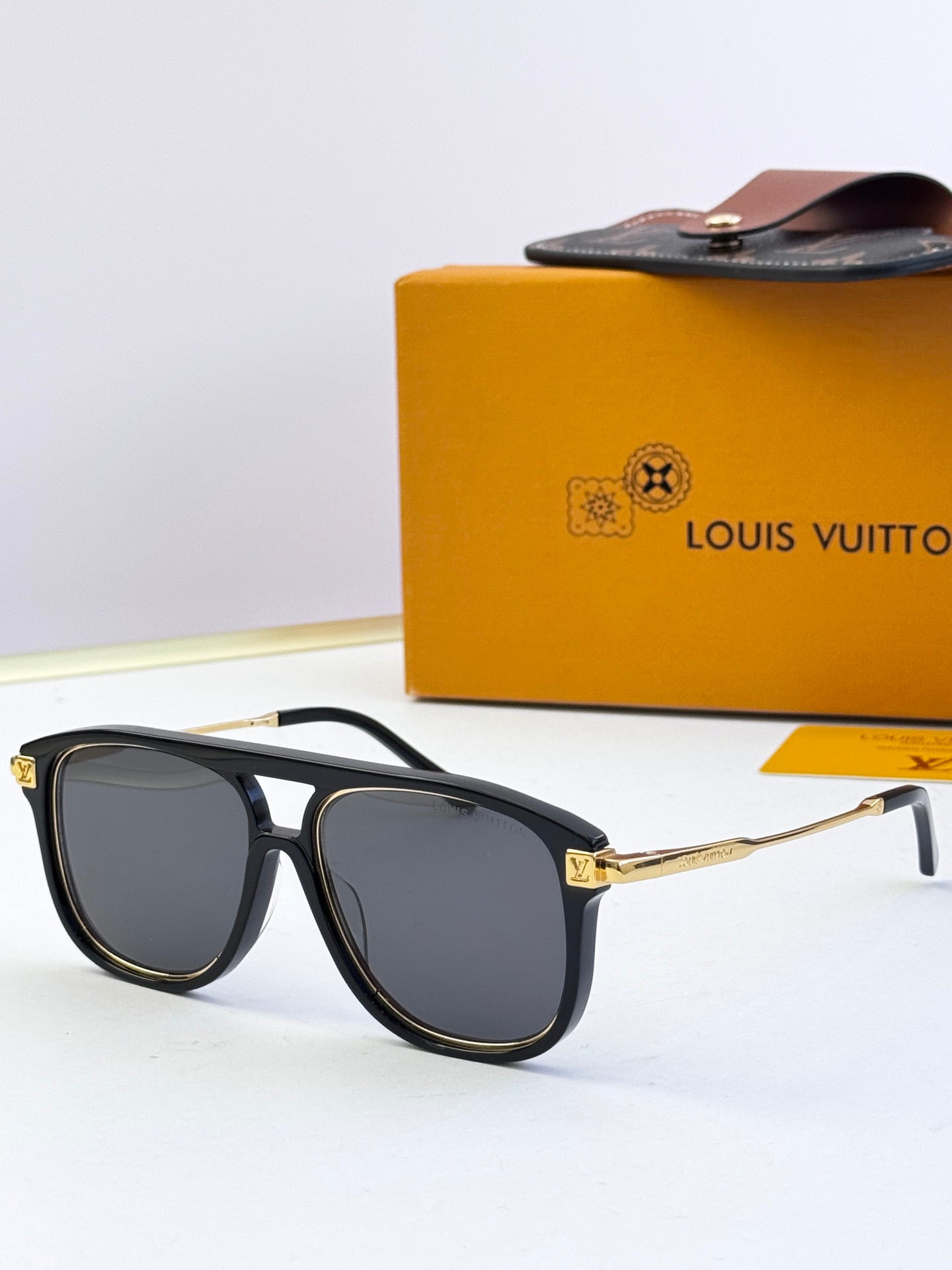 Louis Vuitton sunglasses with black frames, dark lenses, and gold logo detail