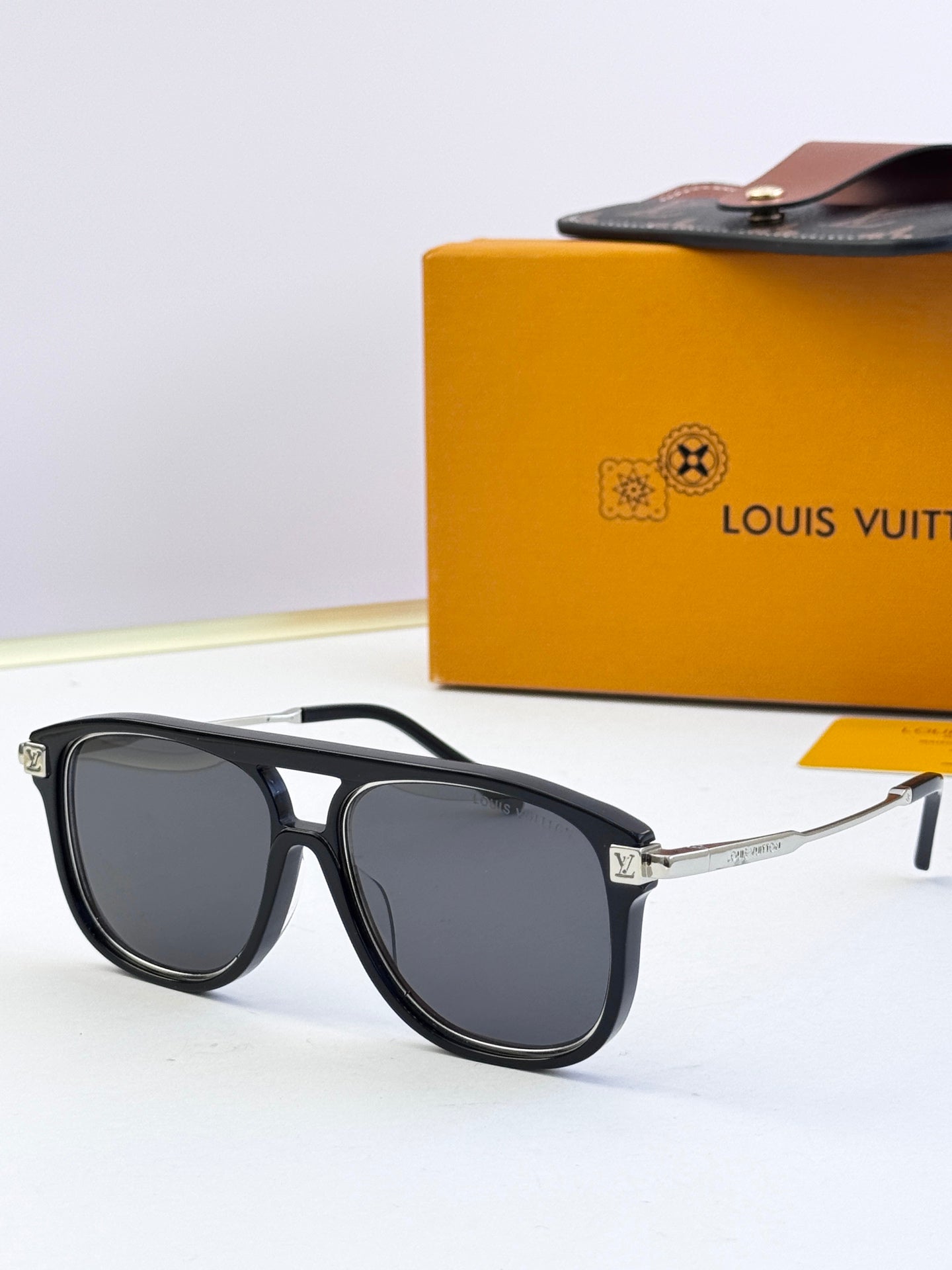 Sunglasses with black frames and dark lenses, gold-tone hinge and temples