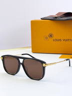 Sunglasses with black frames and brown-tinted lenses, gold-tone logo detail