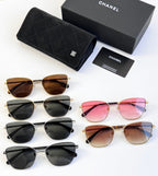 Assorted Chanel sunglasses on display: black, brown, and pink lenses with gold-tone frames