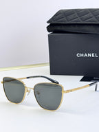 Chanel sunglasses with gray lenses, gold-tone metal frames, rounded cat-eye silhouette