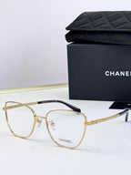 Gold metal eyeglasses with clear lenses, square frames, and engraved temples