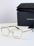 Gold eyeglasses with clear lenses; tortoise-pattern bridge and textured temples