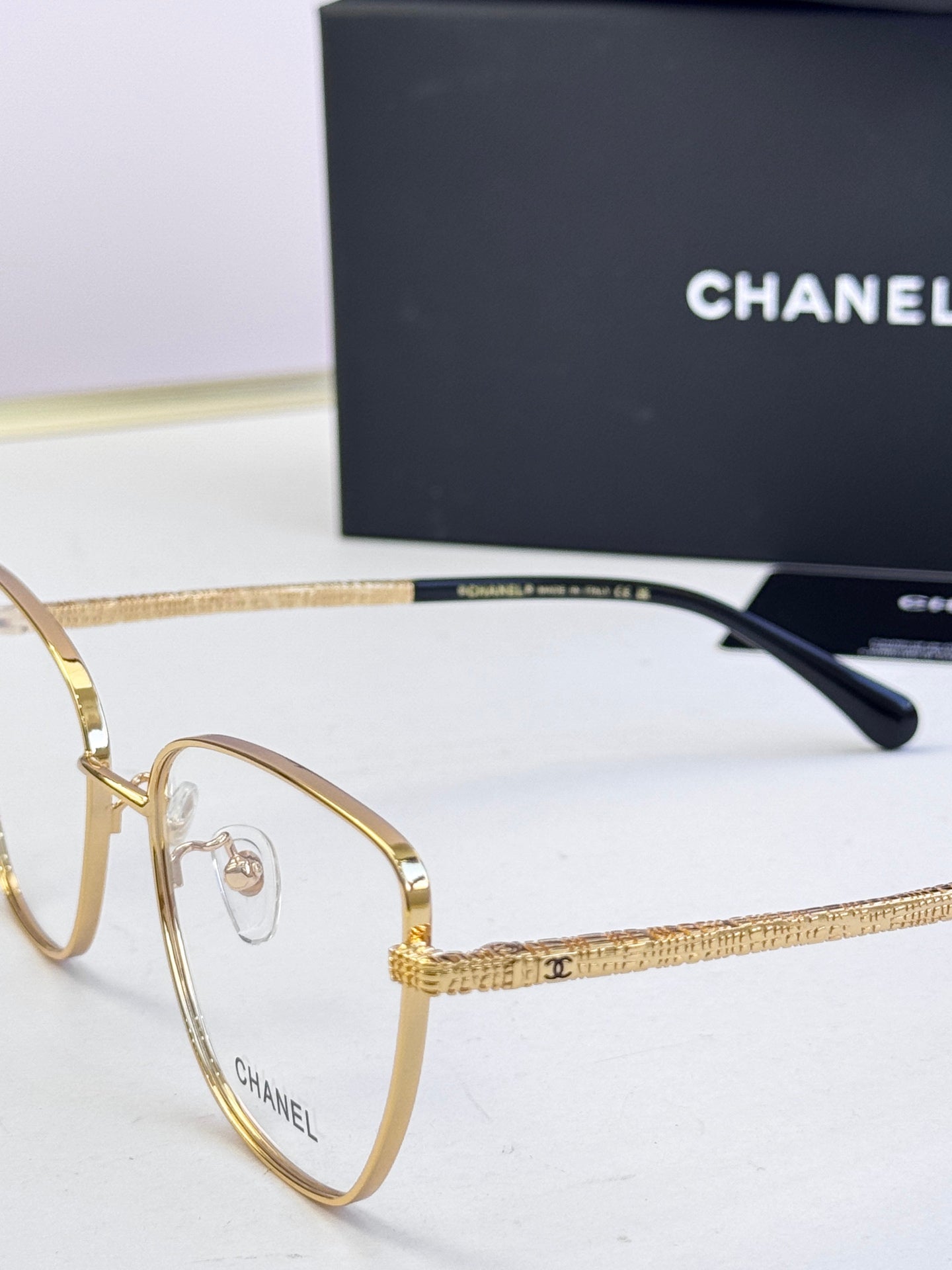Gold eyeglasses close-up with textured arm and dark temple tip