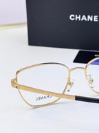 Gold metal eyeglasses with clear lenses and engraved temple branding