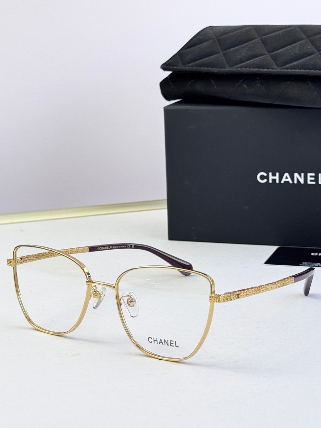 Gold metal eyeglasses with clear lenses and textured gold temples