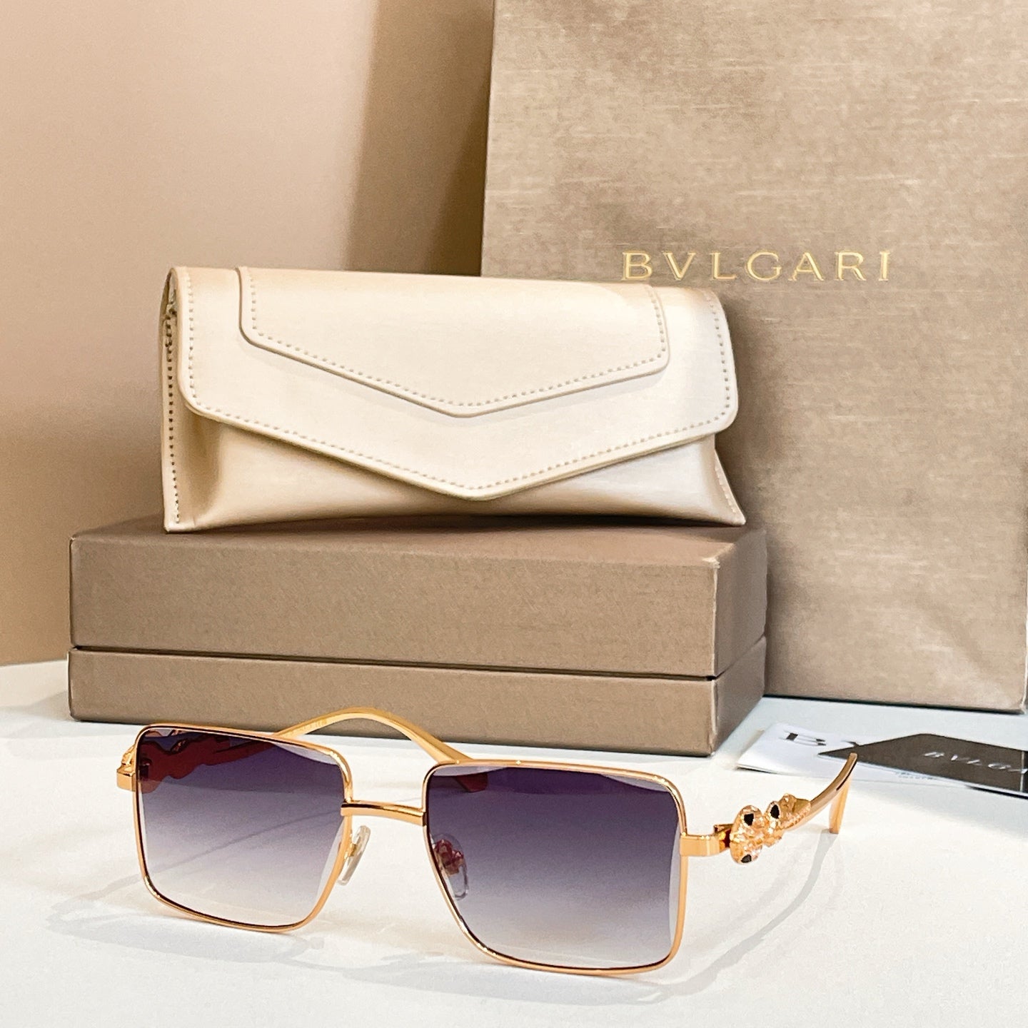 Gold-framed square sunglasses with violet gradient lenses and jeweled side ornament