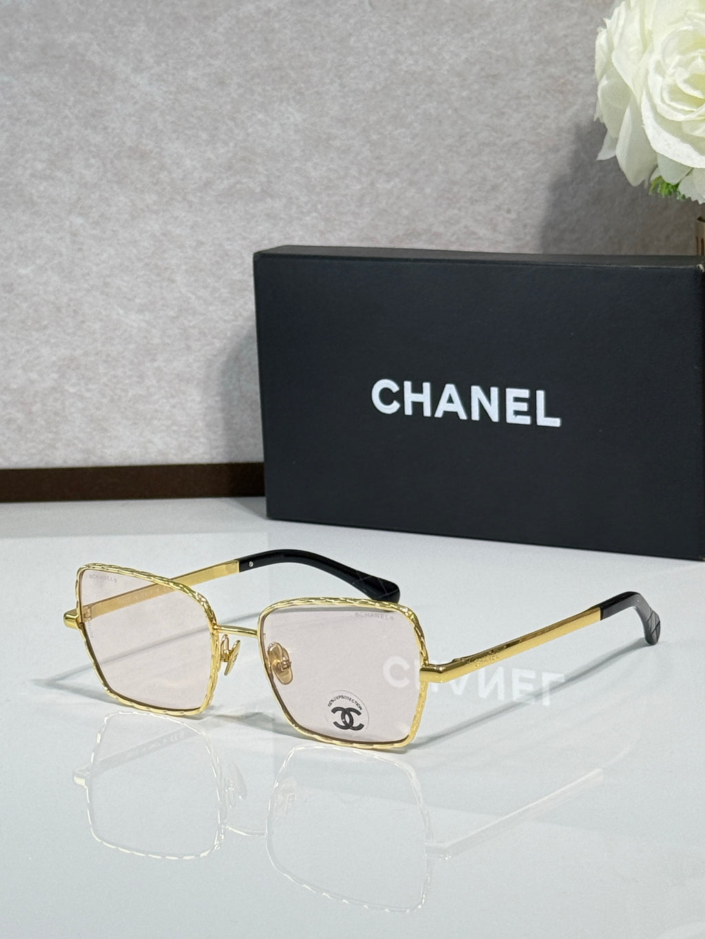 Square gold-tone eyeglasses with gray lenses, Chanel logo on temples