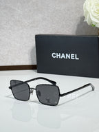 Square black eyeglasses with dark lenses, Chanel logo on temples