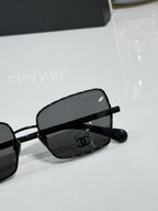 Black eyeglasses close-up with Chanel logo on lens