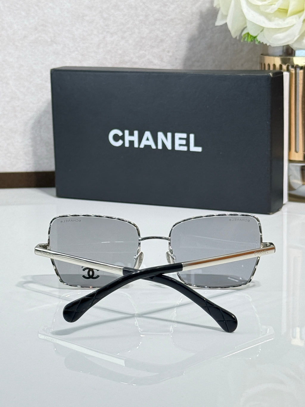 Square silver-tone eyeglasses with gray lenses, Chanel logo on temples