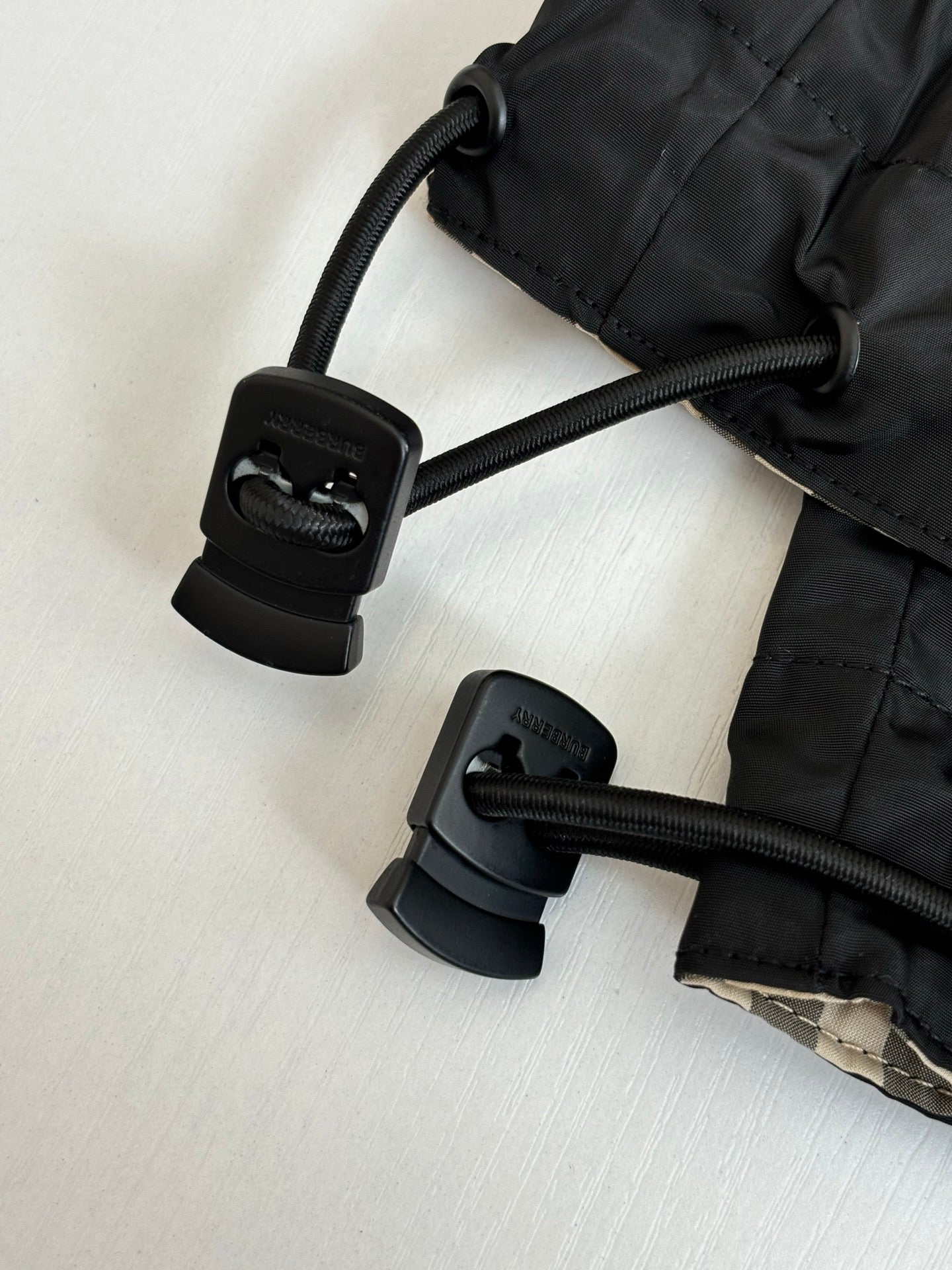 Black jacket hood drawcord with adjustable toggles and cord loops