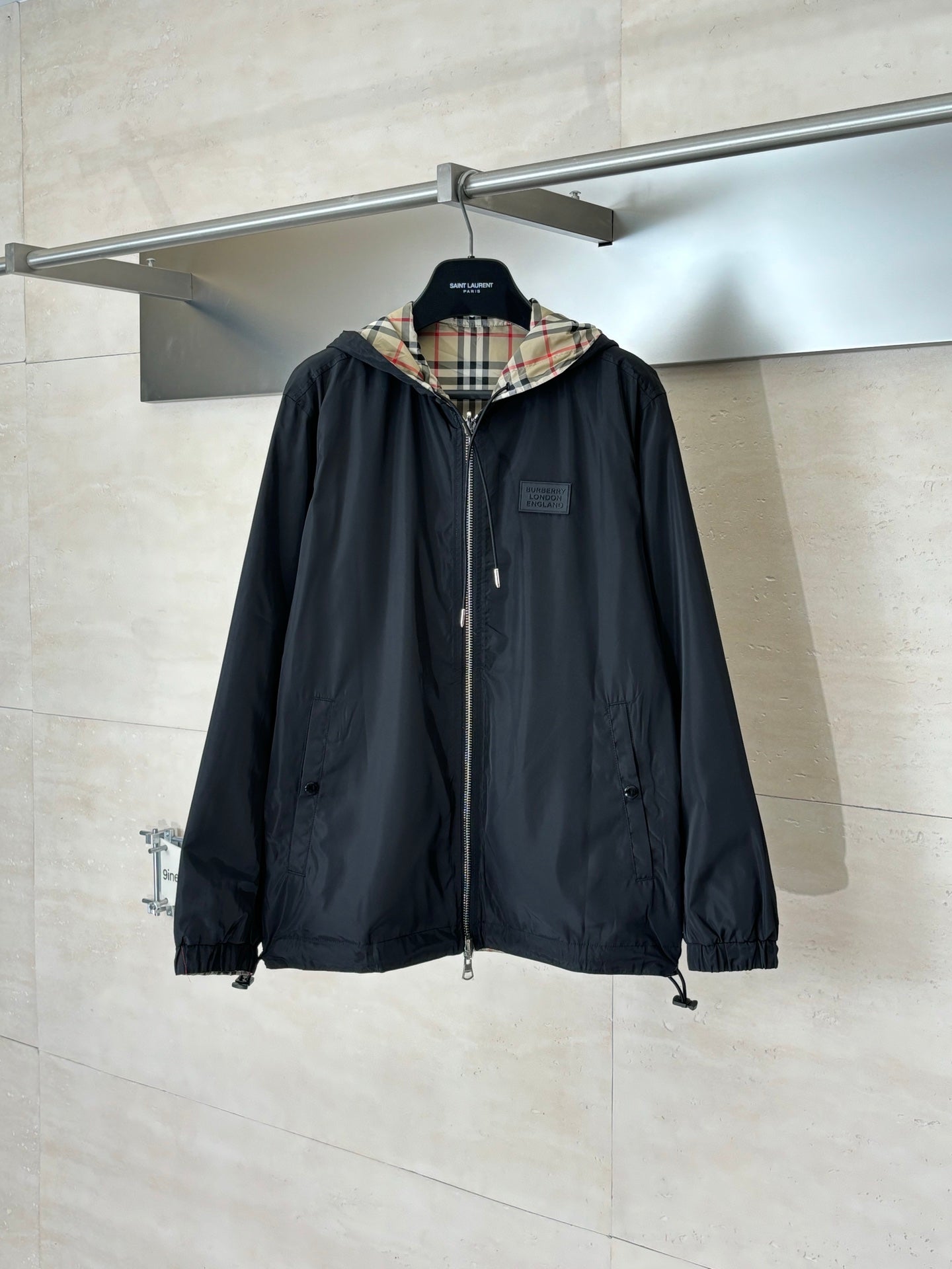 Black hooded jacket with front zipper and plaid-lined hood