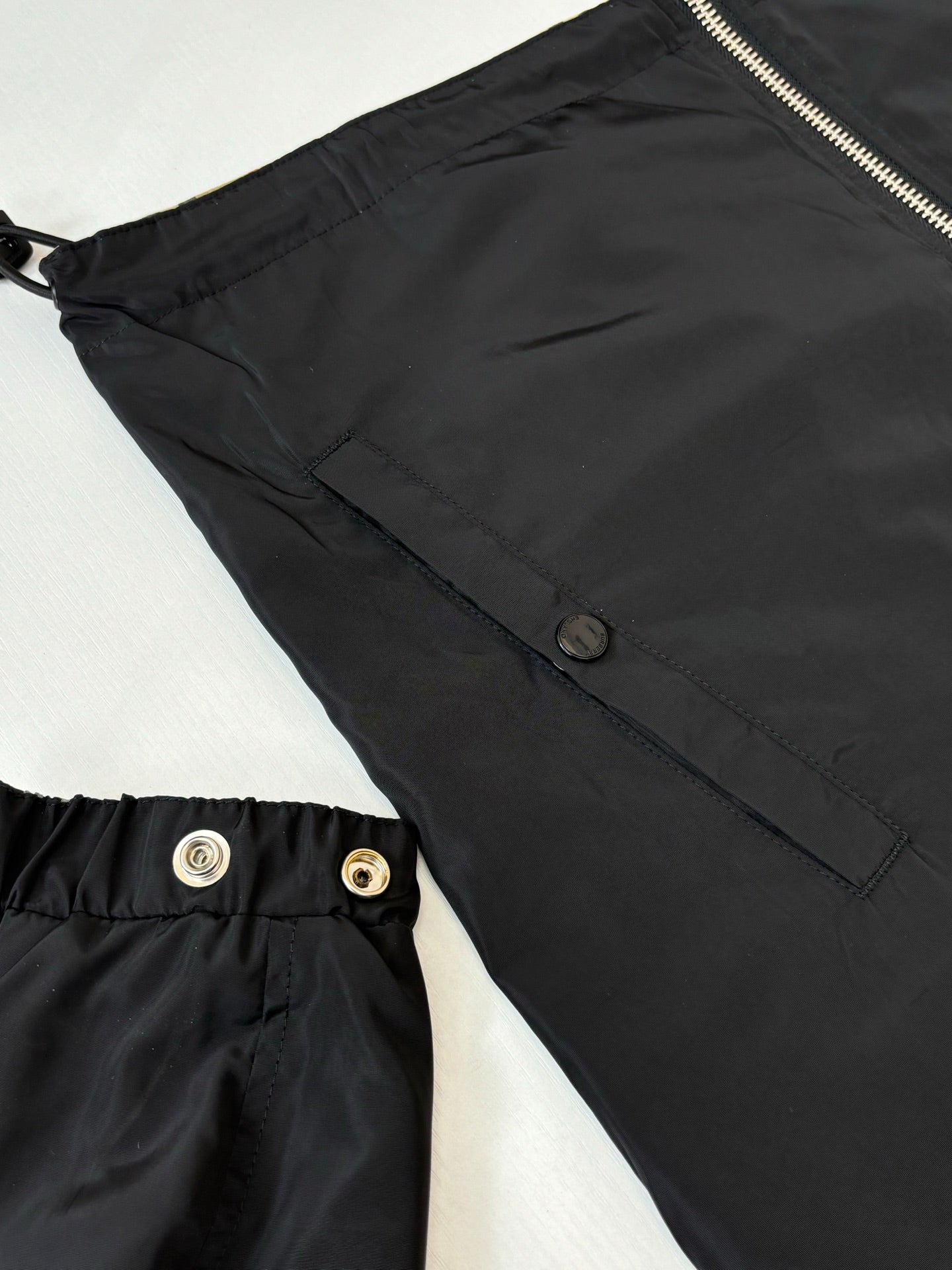Close-up of kids black jacket hooded style with snap and zipper hardware