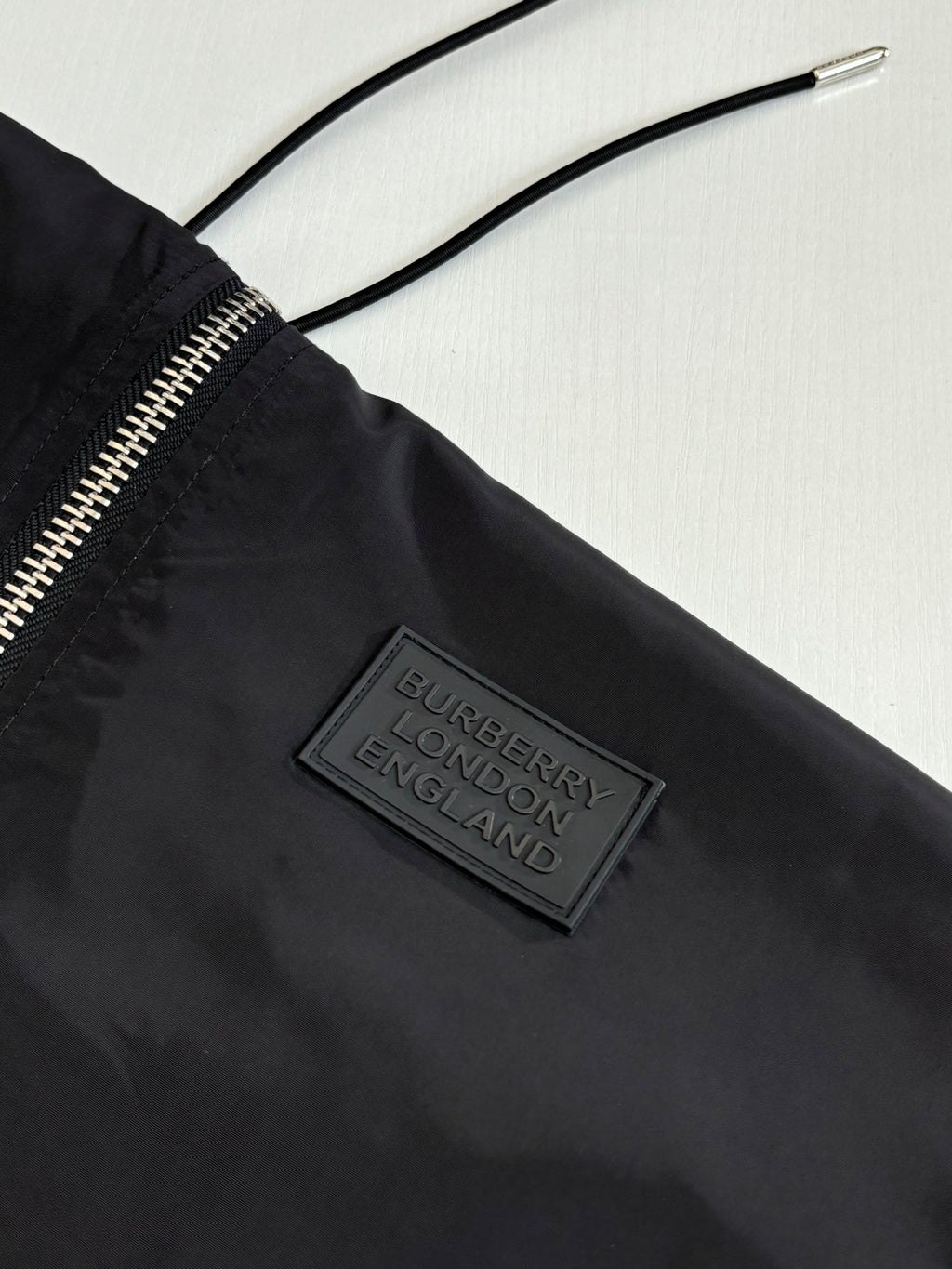 Black long jacket label near zipper with drawstring hood cords