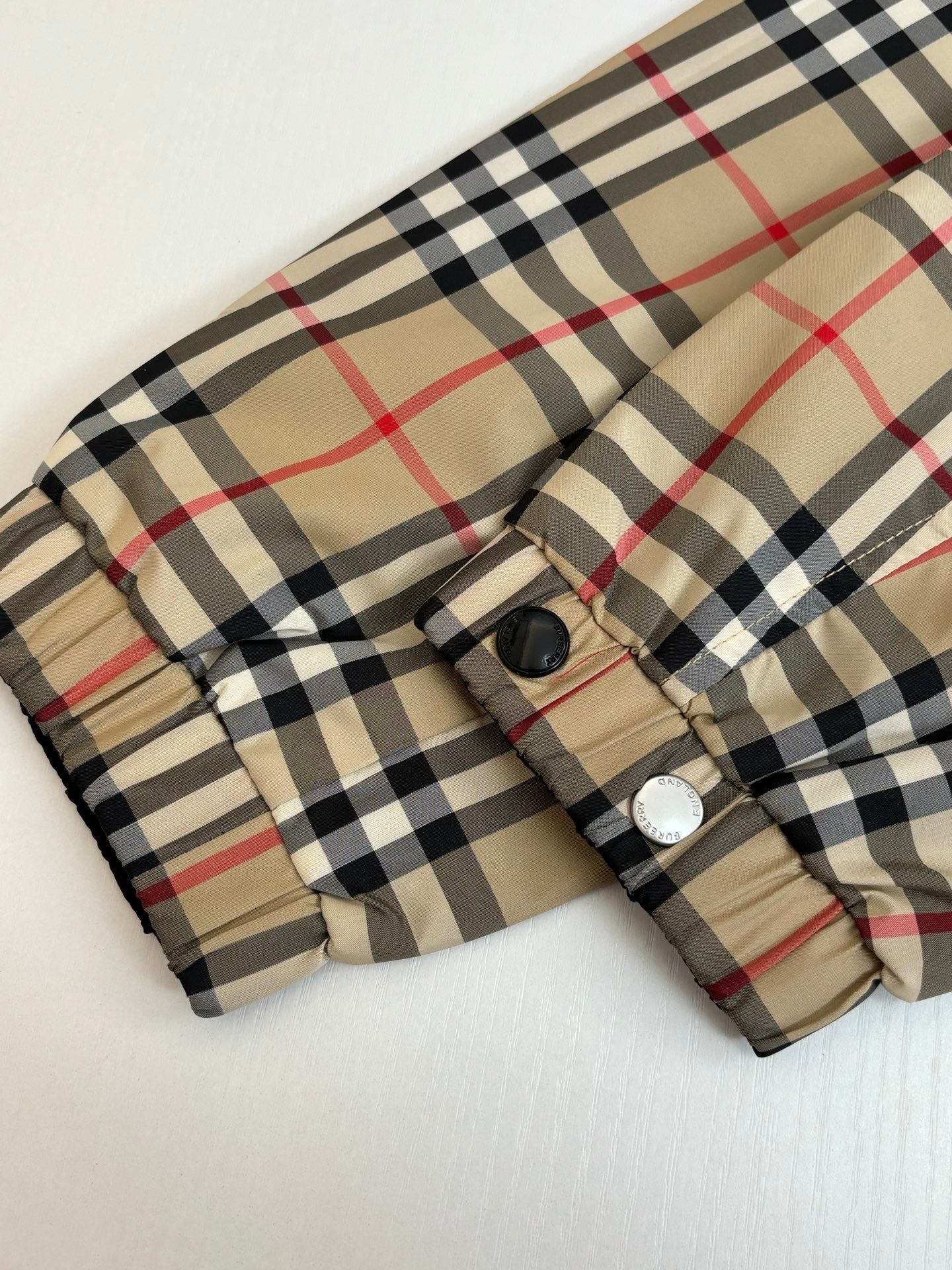 Checkered long jacket sleeve cuff with button snaps and drawstring toggle