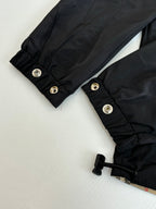 Black jacket cuffs with snap buttons and folded elastic hem