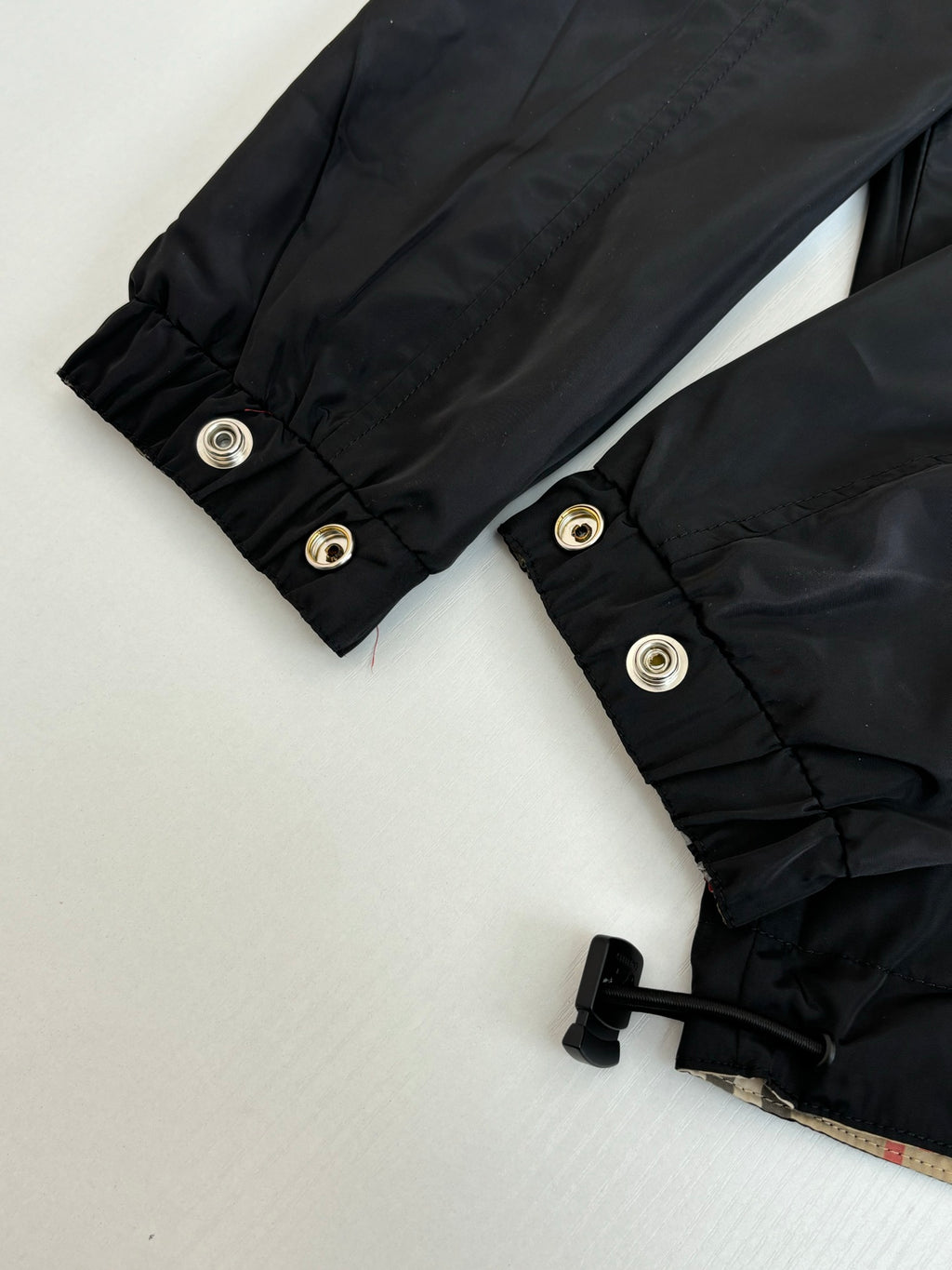 Black jacket cuffs with snap buttons and folded hem