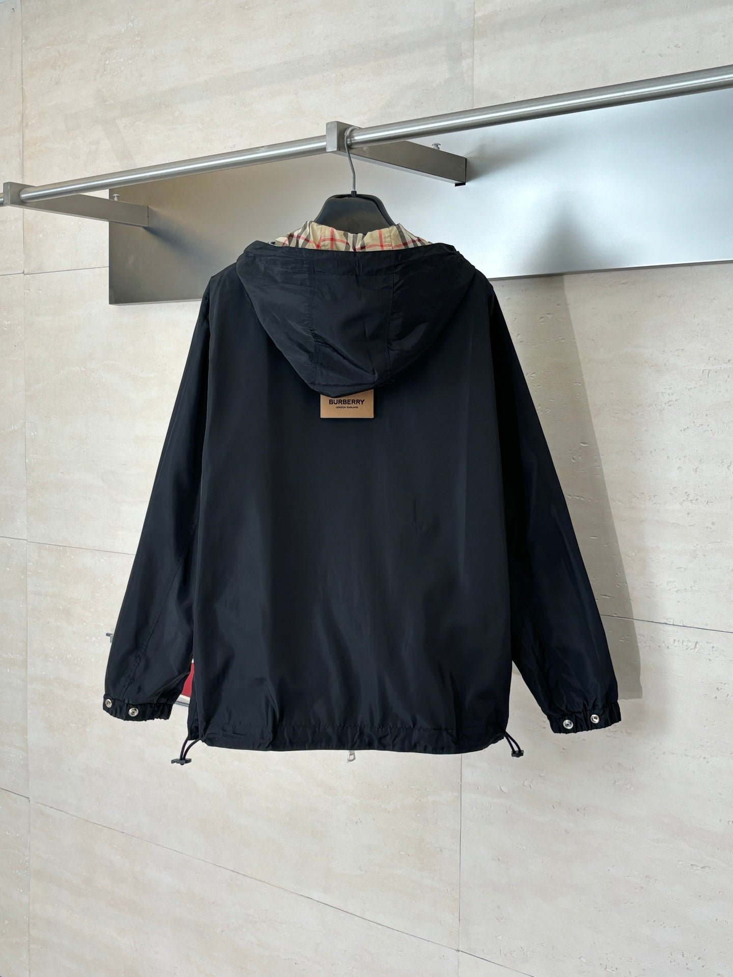 Kids black hooded jacket with rear view and adjustable drawstring hem