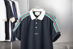 Gucci short-sleeve polo shirt with navy body, white collar, and multicolor shoulder stripes