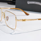 Gold rectangular eyeglasses close-up with amber temples and clear lenses