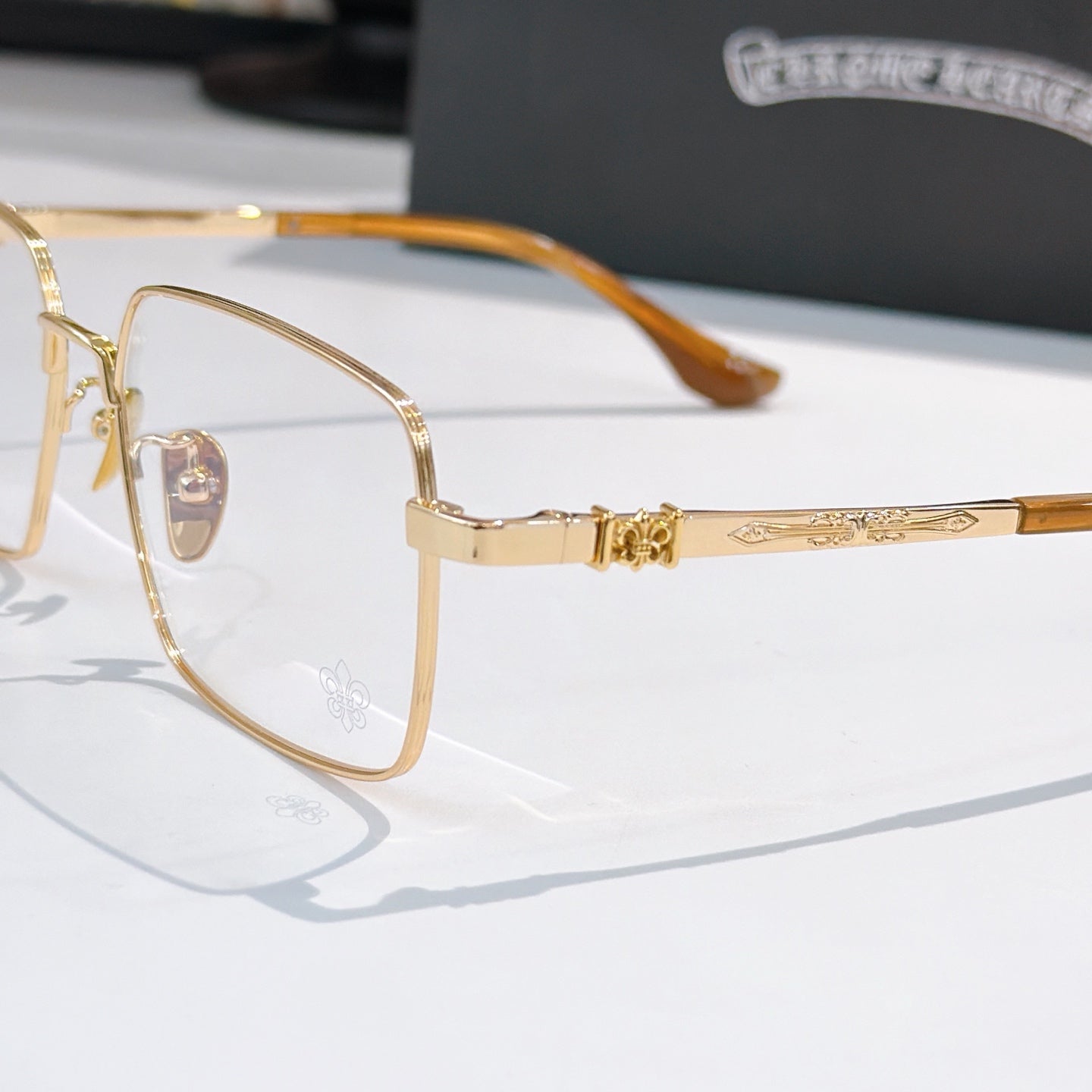 Gold rectangular eyeglasses close-up with amber temples and clear lenses