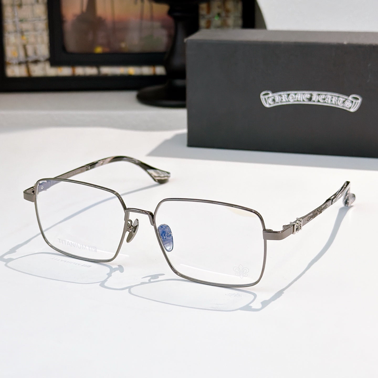 Chrome frame rectangular eyeglasses with blue temples and clear lenses, side view