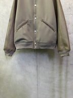 Olive jacket front with snap buttons and diagonal zip pockets