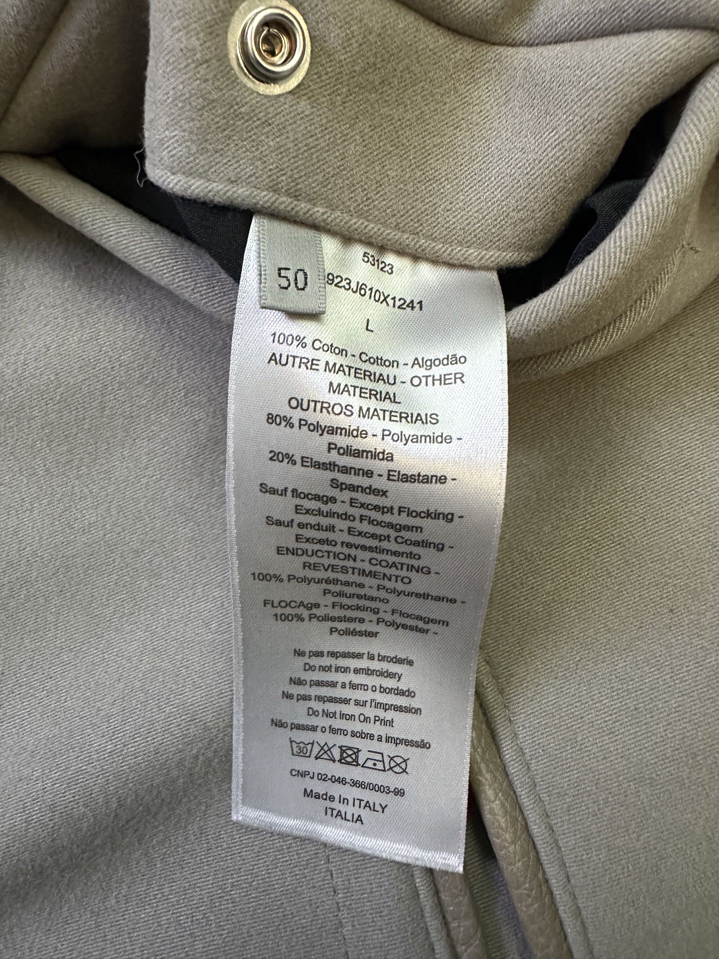 Clothing care label sewn inside neck, showing materials and washing instructions
