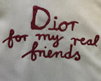Burgundy embroidered text: “Dior for my real friends” on olive fabric