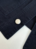 Prada long jacket sleeve close-up with round metal button on dark navy fabric