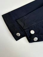 Prada long jacket cuff close-up with round metal buttons on dark navy