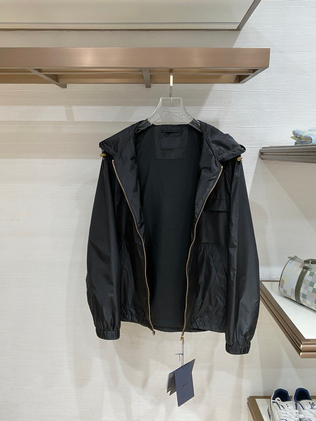 Black hooded jacket back view with hood, long sleeves, and full-length front zip.