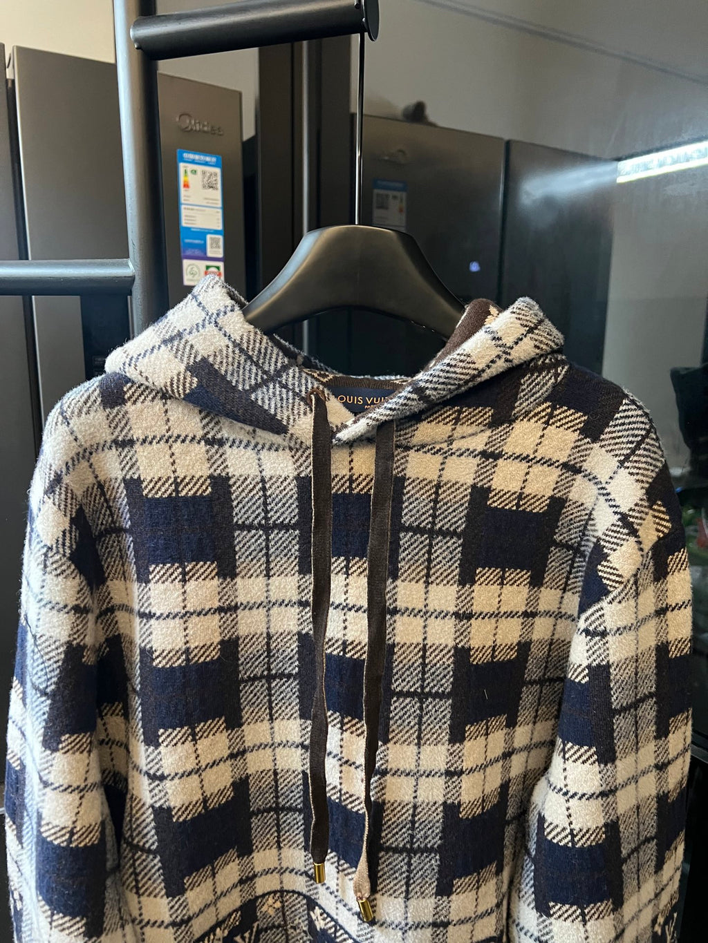 Plaid zip-up hoodie with cream and navy blocks, hood, and drawstring details