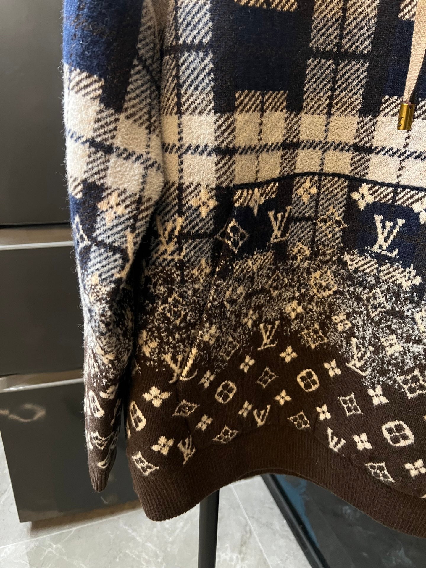 Brown monogram panel on long-sleeve hoodie with cream-and-navy plaid upper
