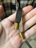 Metal-tipped drawstring ends on plaid hood, gold caps with small LV-style emblem