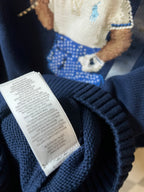 Dark blue knit sweater care label tag on inside neckline area