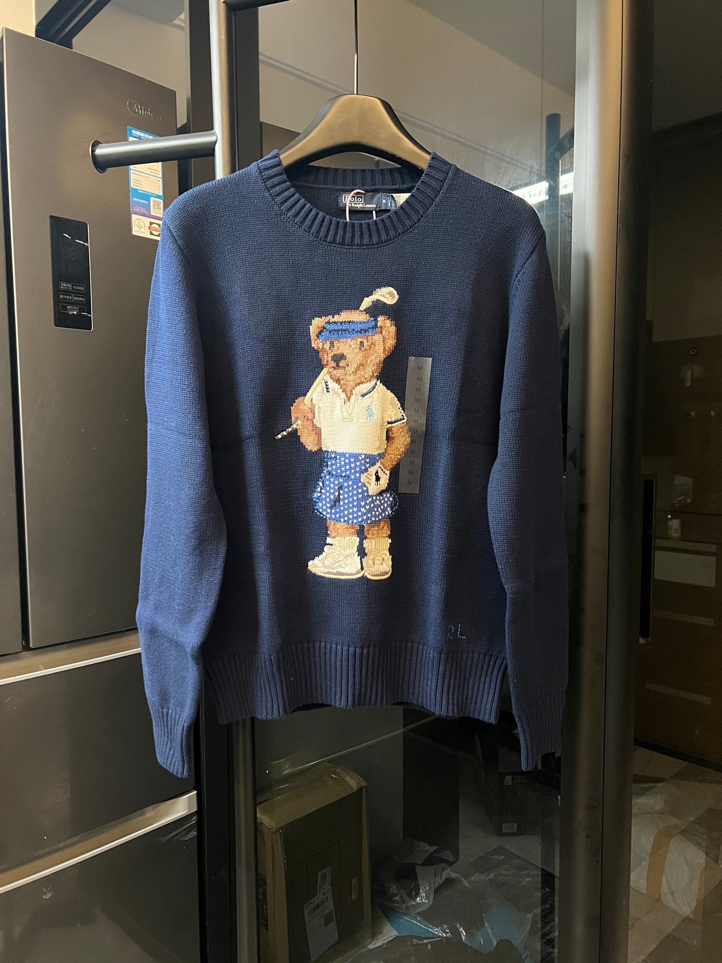 Dark blue knit sweater with embroidered bear character graphic on front