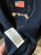 Navy knit sweater sleeve with care label tag near the hem