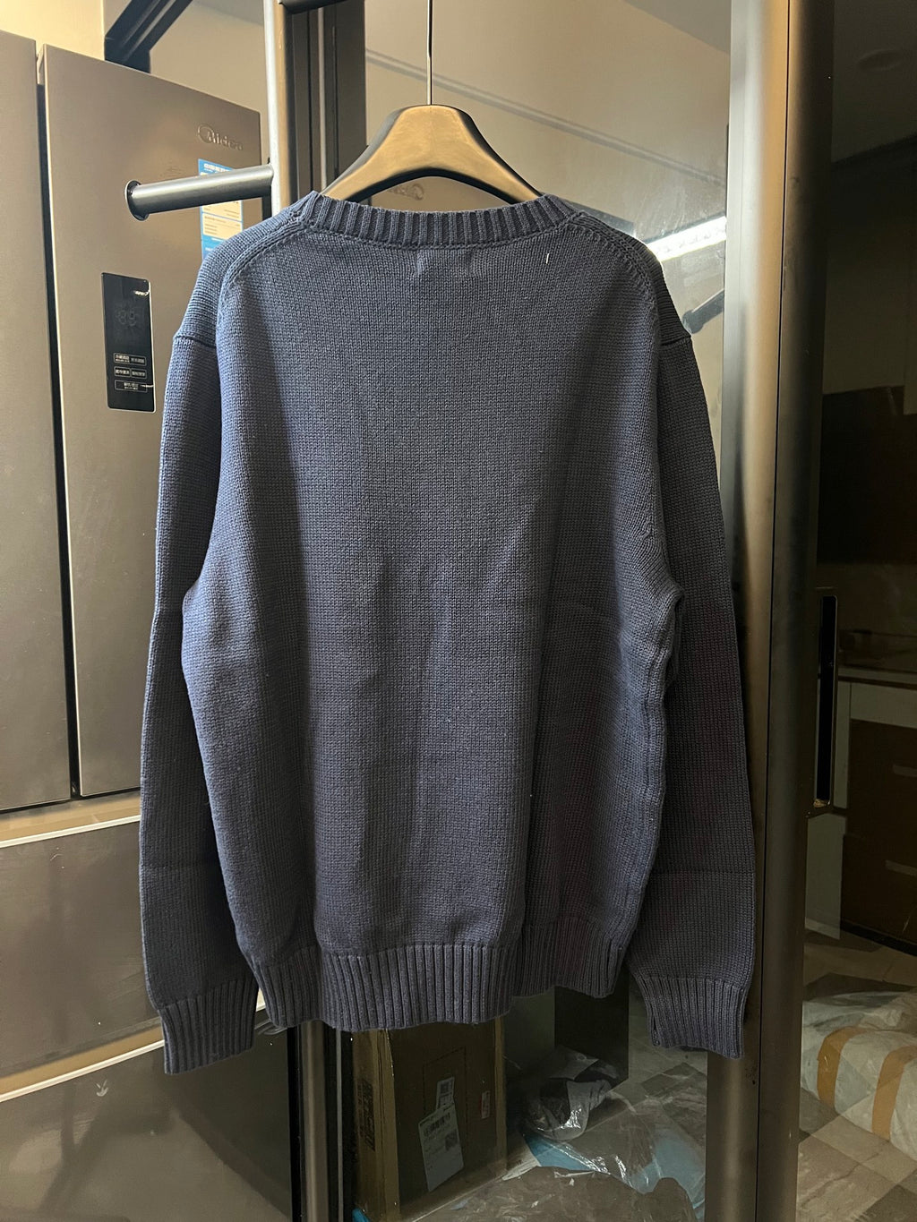 Back view navy knit sweater with ribbed collar, cuffs, and hem