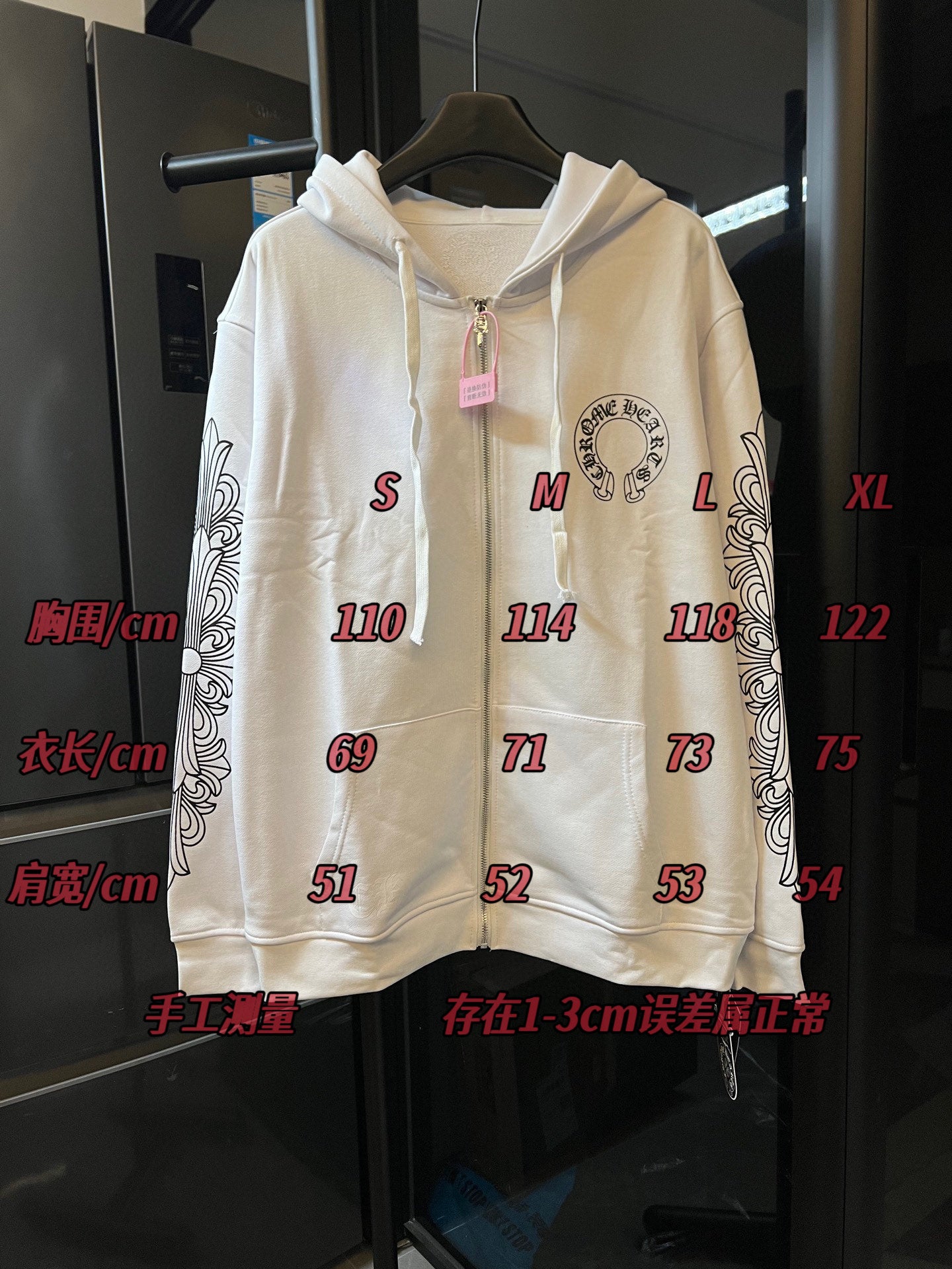 Light cream zip-up hoodie with hood and circular chest logo, on retail display.