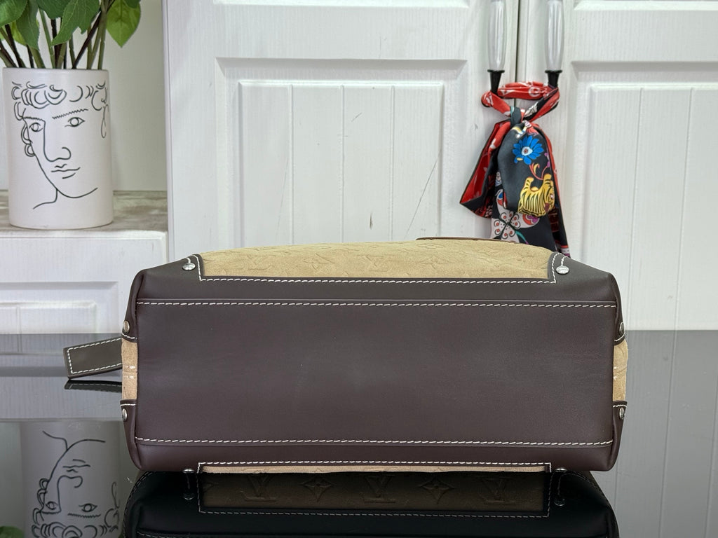 Dark brown Louis Vuitton bag with gold hardware, top flap, and stitched front pocket