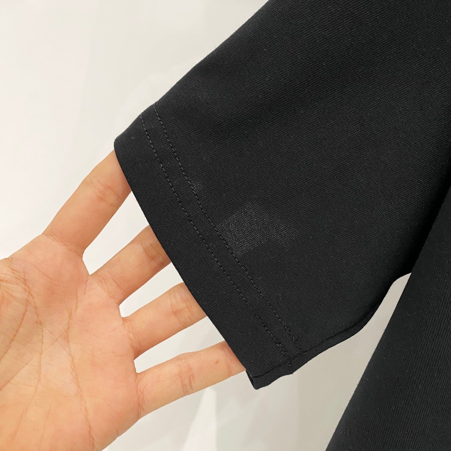 Black T-shirt sleeve hem with visible double stitching