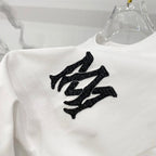 White Amiri T-shirt close-up of large black graphic logo
