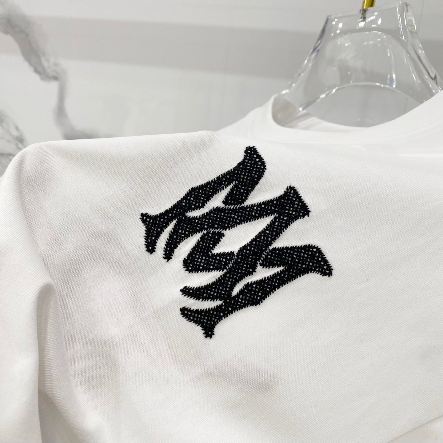 White Amiri T-shirt close-up of large black graphic logo