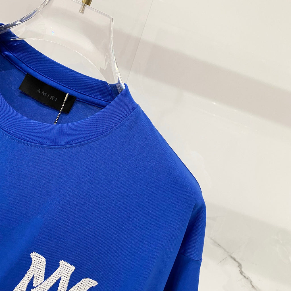Blue T-shirt showing ribbed crew collar and neckline tag