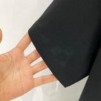 Black T-shirt hem and side seam held in hand