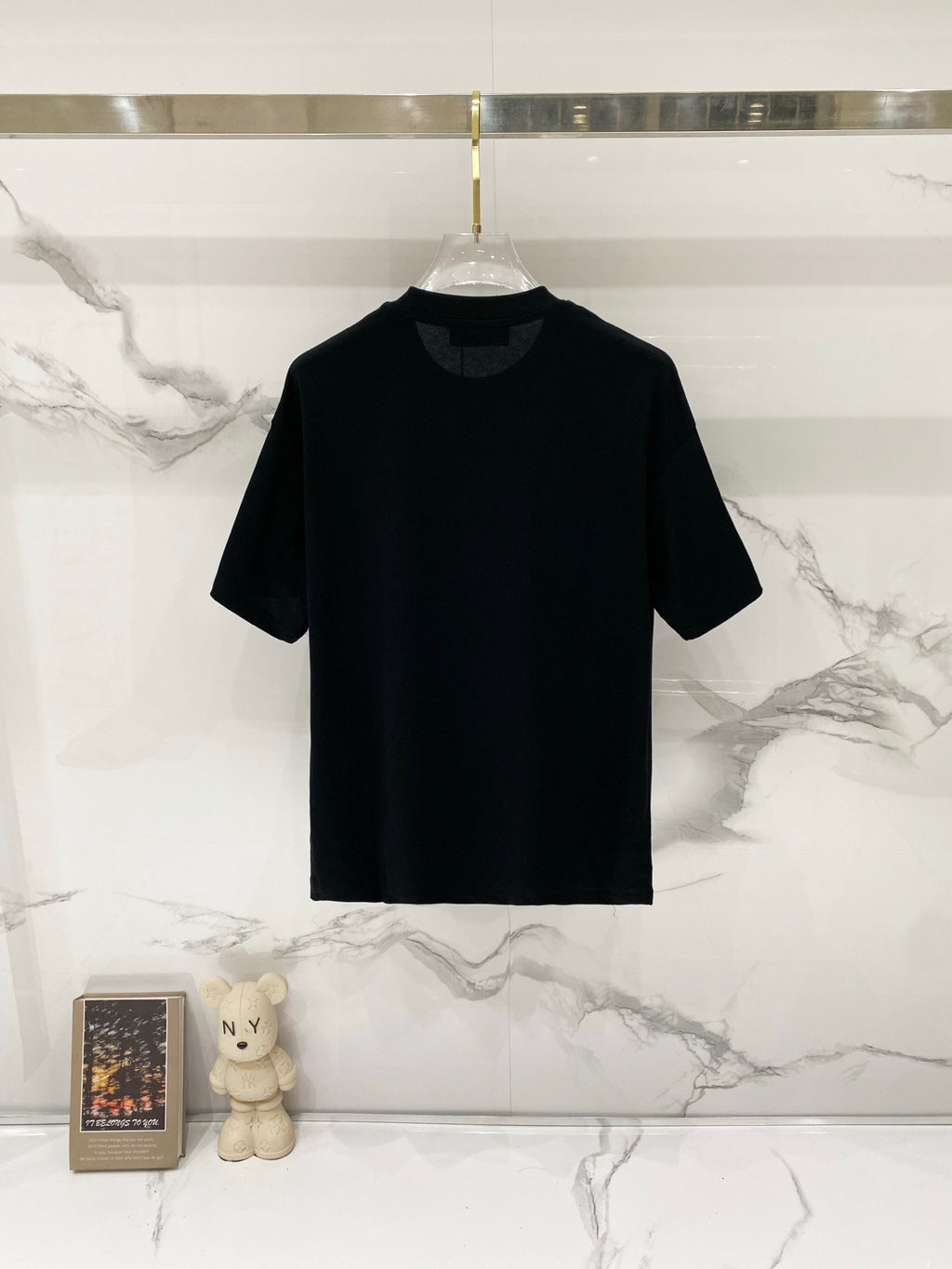 Black crew-neck T-shirt on hanger, short sleeves
