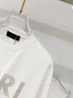 White crewneck T-shirt close-up with AMIRI logo detail and neckline tag