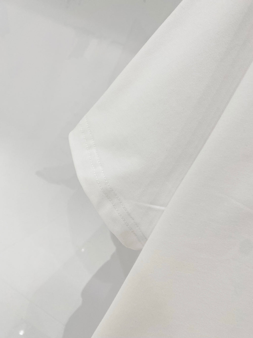 White crewneck T-shirt fabric close-up with stitched collar